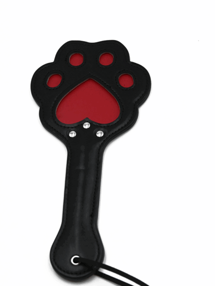 Black leather spanking paddle in the shape of a cat paw with red cutout detailing