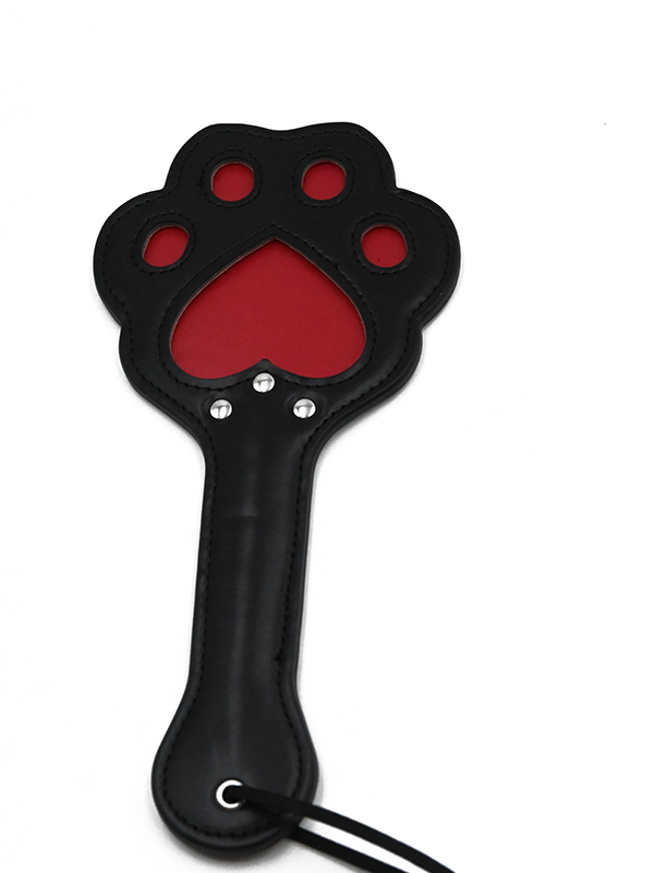 Black leather spanking paddle in the shape of a cat paw with red cutout detailing